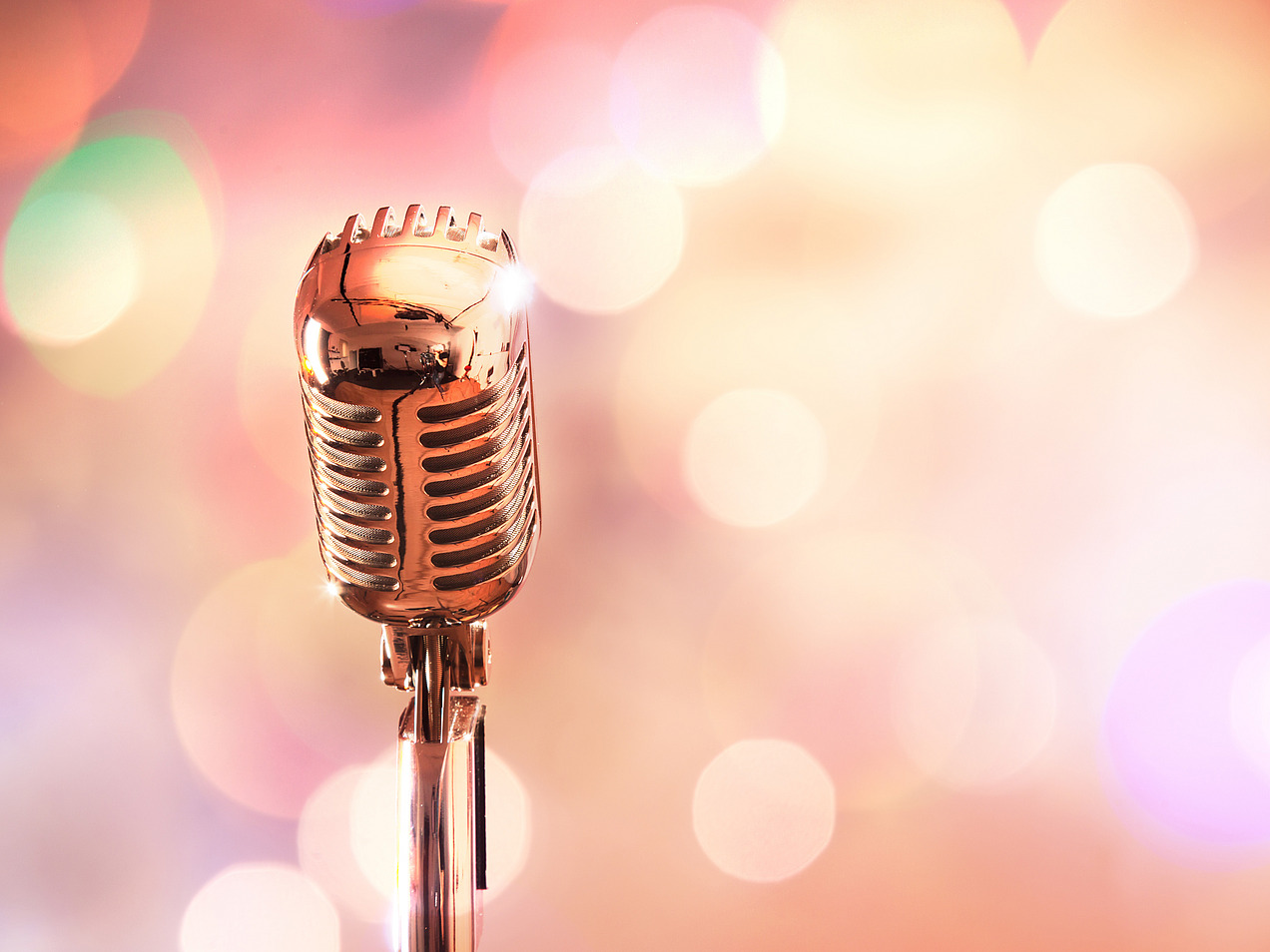 A retro microphone in front of a colorful spotlight
