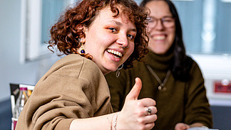 Drei Studierende zeigen den Daumen hoch