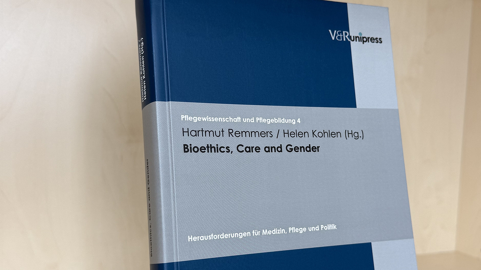 Ein Fachbuch von Hartmut Remmers und Helen Kohlen mit dem Titel "Bioethics, Care and Gender" steht in einem Regal.