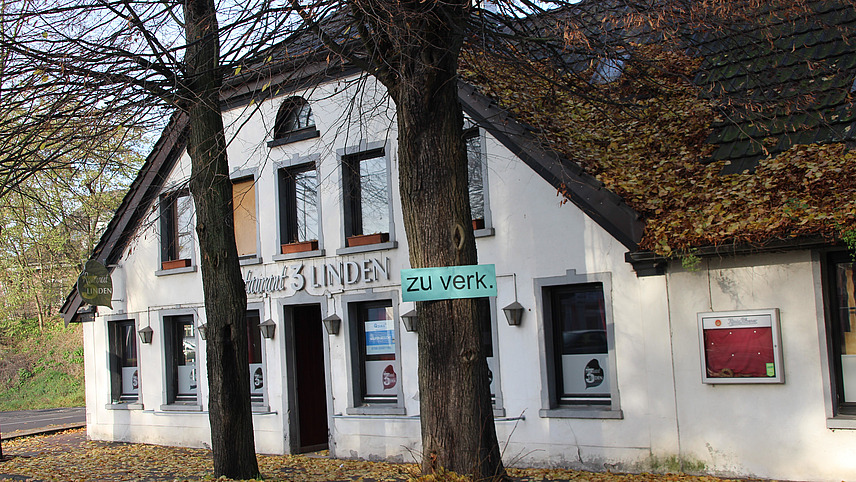 A for-sale sign in front of a former restaurant