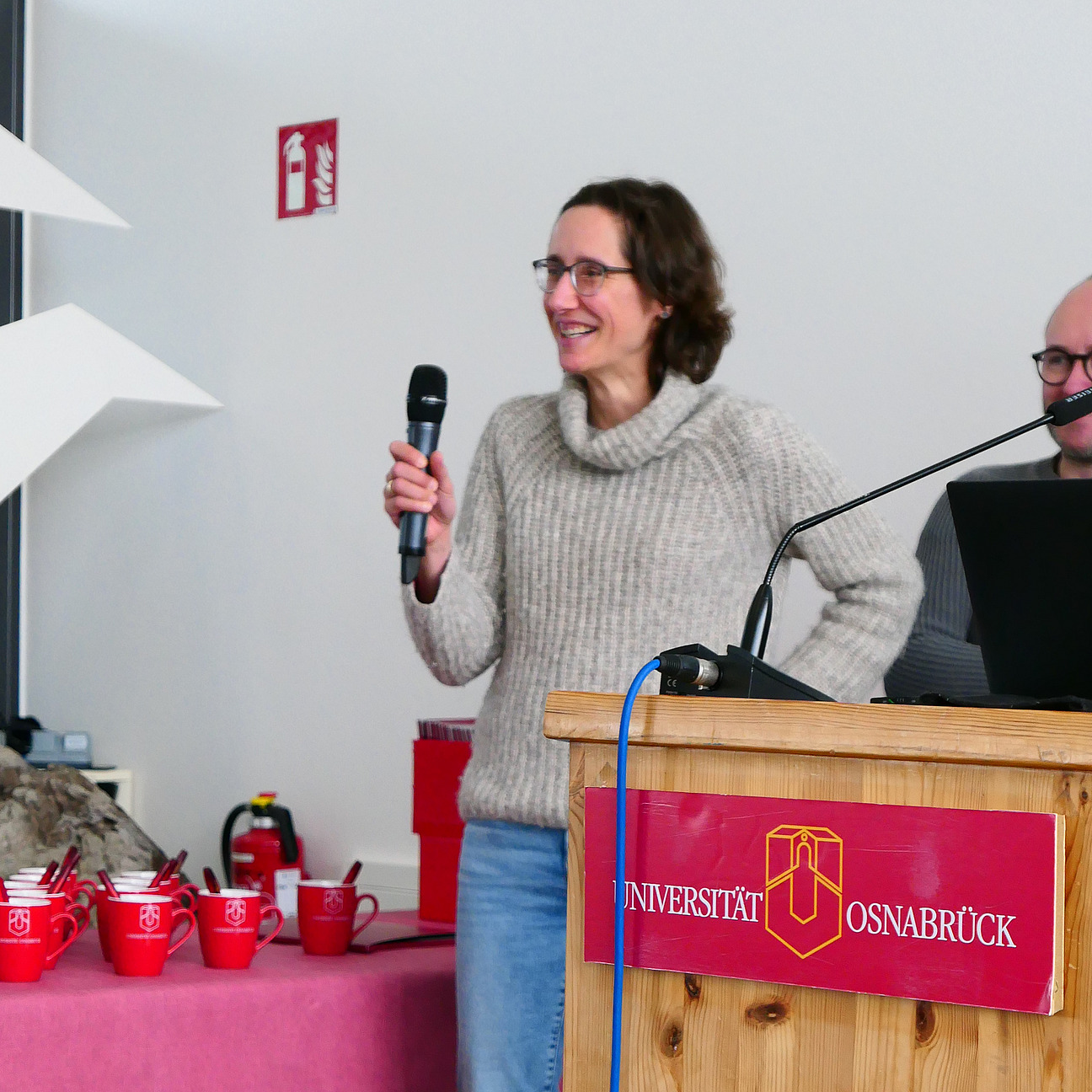Ein Dozentin h&auml;lt ein Mikrofon in der Hand.