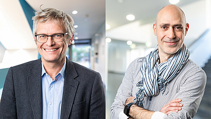 Zwei M&auml;nner l&auml;cheln in die Kamera