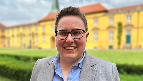 Foto von Yvonne P&uuml;ttmann vor dem Schloss der Universit&auml;t Osnabr&uuml;ck