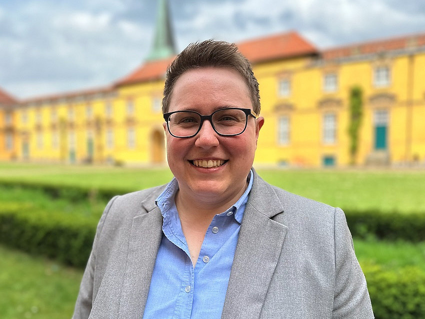 Foto von Yvonne P&uuml;ttmann vor dem Schloss der Universit&auml;t Osnabr&uuml;ck