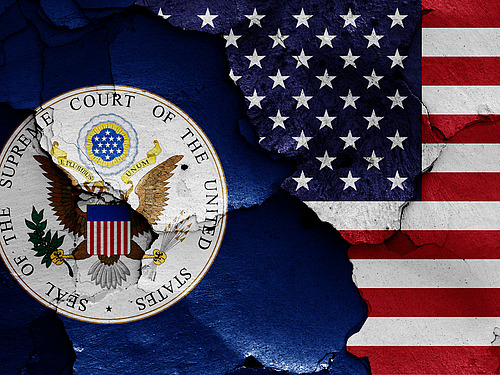 flags of Supreme Court of the United States and USA painted on cracked wall