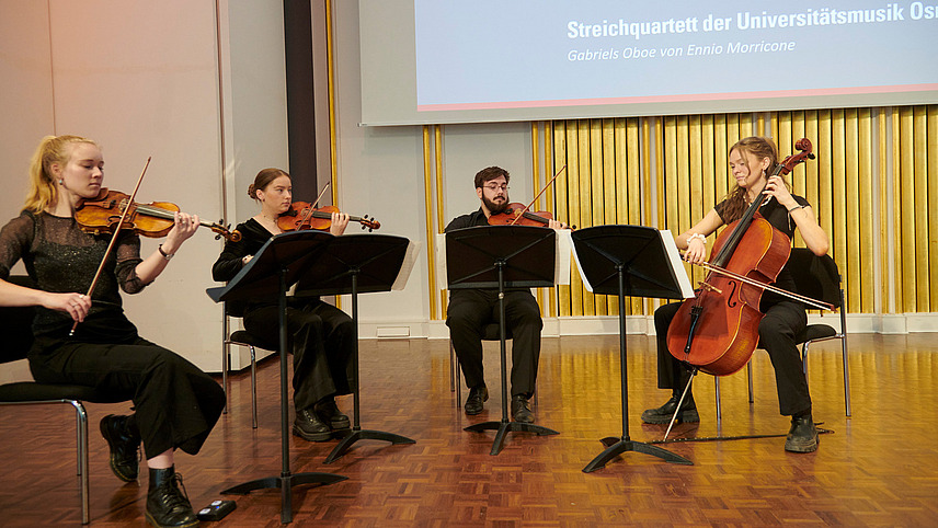 Four people with string instruments on one stage