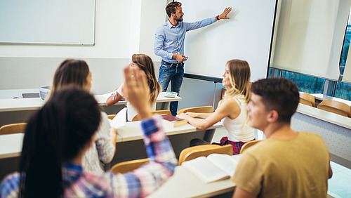 Seminarraum mit Student*innen und Dozent