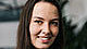 young woman with dark long hair smiles into the camera