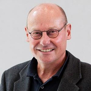 Mann mit Brille lächelt.