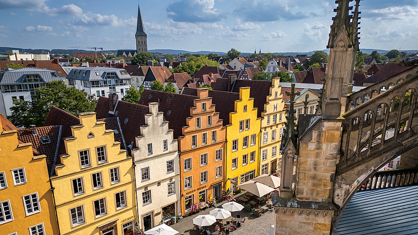 Bunte Giebelh&auml;user der Altstadt in der Sonne, fotografiert von oben mit Blick aufs Stadtpanorama.