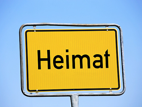 Ein gelbes Straßenschild mit dem Wort "Heimat".