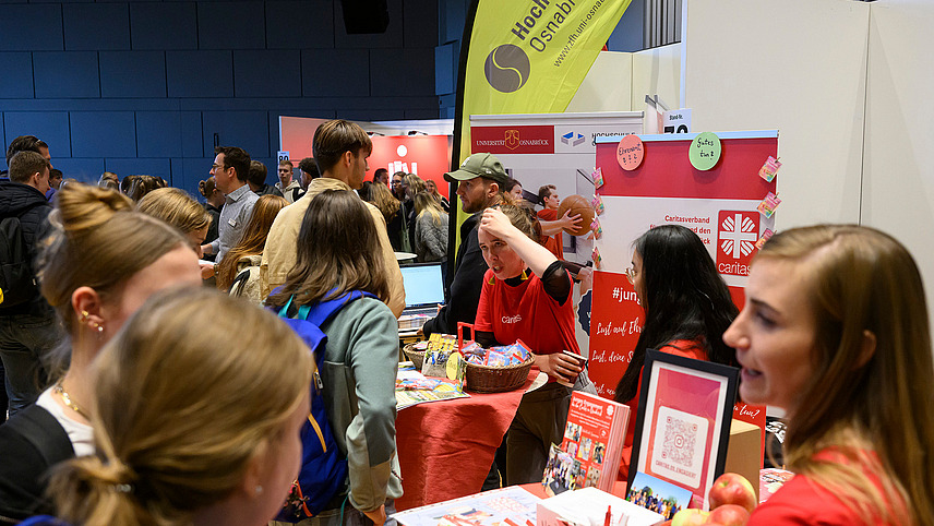 View of colorful exhibition stands with numerous people gathering information