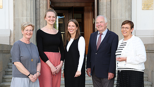 Four women and one man smile into the camera.