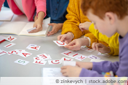 Kinder legen englische Worter aus Papierbuchstaben