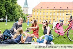 Studierende treffen sich im Schlossgarten zum picknicken, spielen und reden