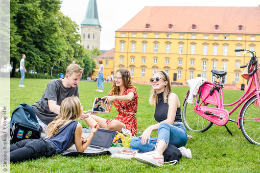 Studierende treffen sich im Schlossgarten zum picknicken, spielen und reden