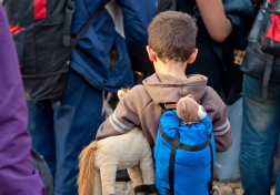 Junge mit Rucksack und Plüschtier in Menschenmenge. Foto: Fotolia/Lydia Geissler