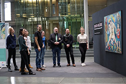 Studerende des Masterfachs Kunst und Kommunikation stehen vor einem Werk des Malers  David Olère in der Ausstellung "Überlebender des Krematoriums III“ im Deutschen Bundestag.