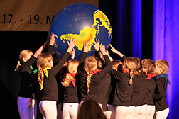 Kinder auf der Bühne halten einen Weltkugel-Ball