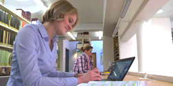 Studentin arbeitet in Bibliothek am Laptop
