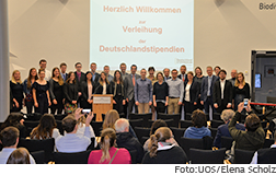 [Translate to English:] Gruppenfoto der Deutschland-Stipendiaten auf der Bühne im Osnabrücker Schloss