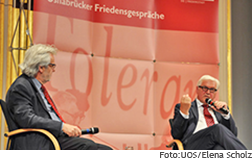 [Translate to English:] Frank Walter Steinmeier und ein weiterer Gast auf dem Podium