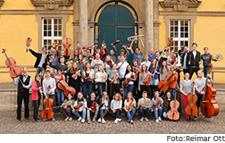 Gruppenfoto Sinfonierorchester der Uni mit Instrumenten vor dem Osnabrücker Schloss