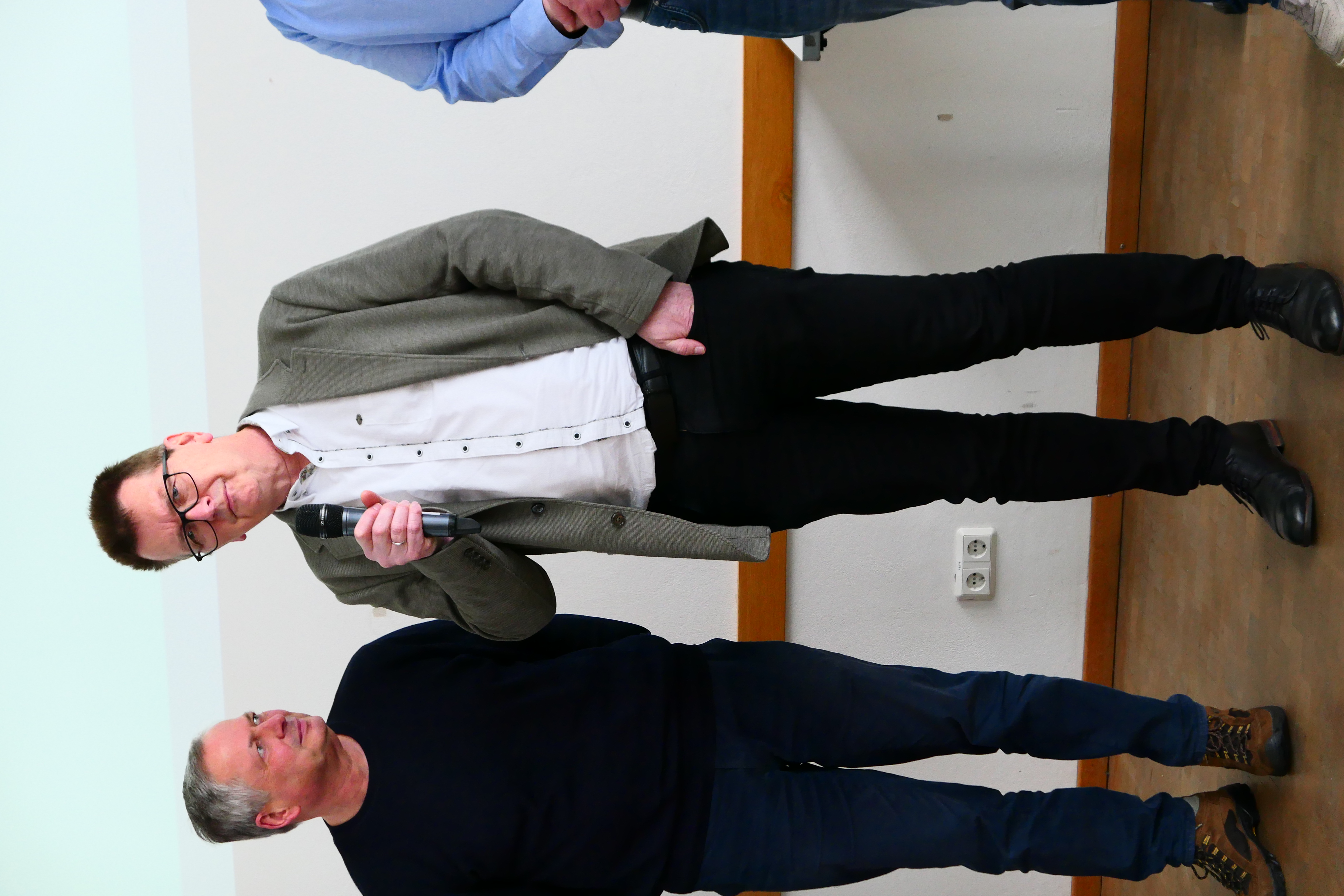 Ein Dozent h&auml;lt ein Mikrofon in der Hand.