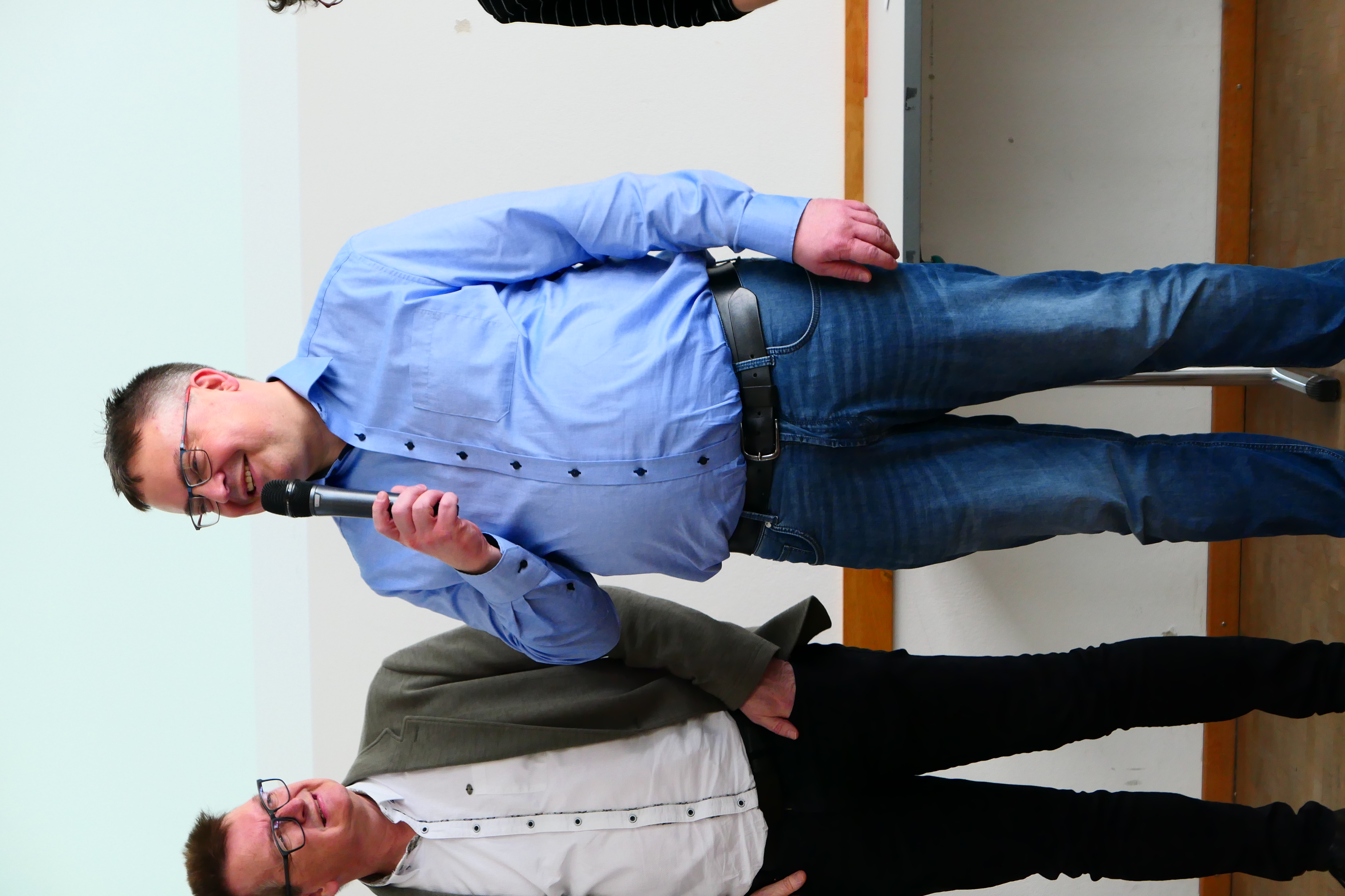 Ein Dozent h&auml;lt ein Mikrofon in der Hand.