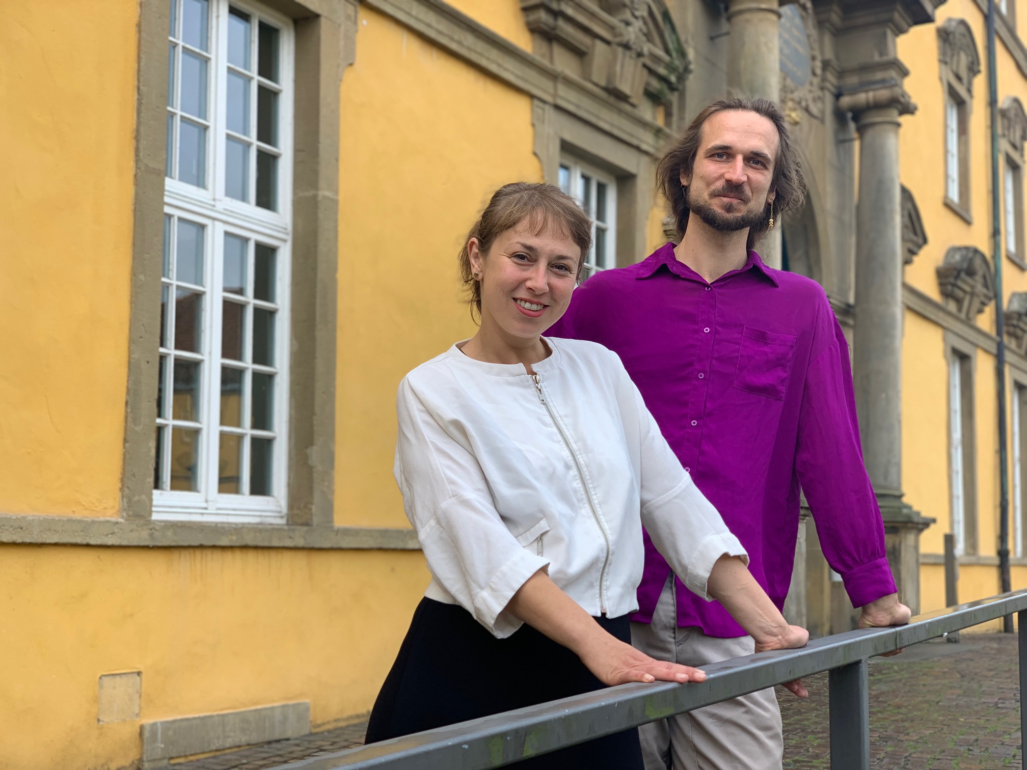 Eine Frau und ein Mann stehen vor dem Osnabrücker Schloss. 